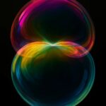 Deux sphères lumineuses et multicolores se rencontrant au centre, formant une zone de fusion irisée évoquant la jonction entre deux réalités ou deux plans de conscience.