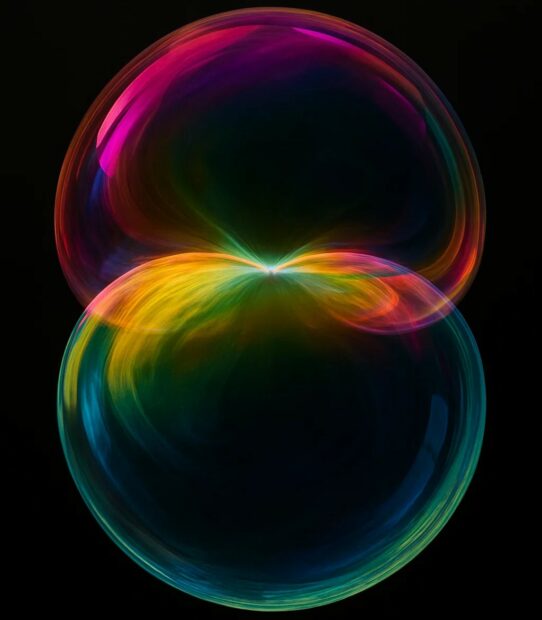 Deux sphères lumineuses et multicolores se rencontrant au centre, formant une zone de fusion irisée évoquant la jonction entre deux réalités ou deux plans de conscience.